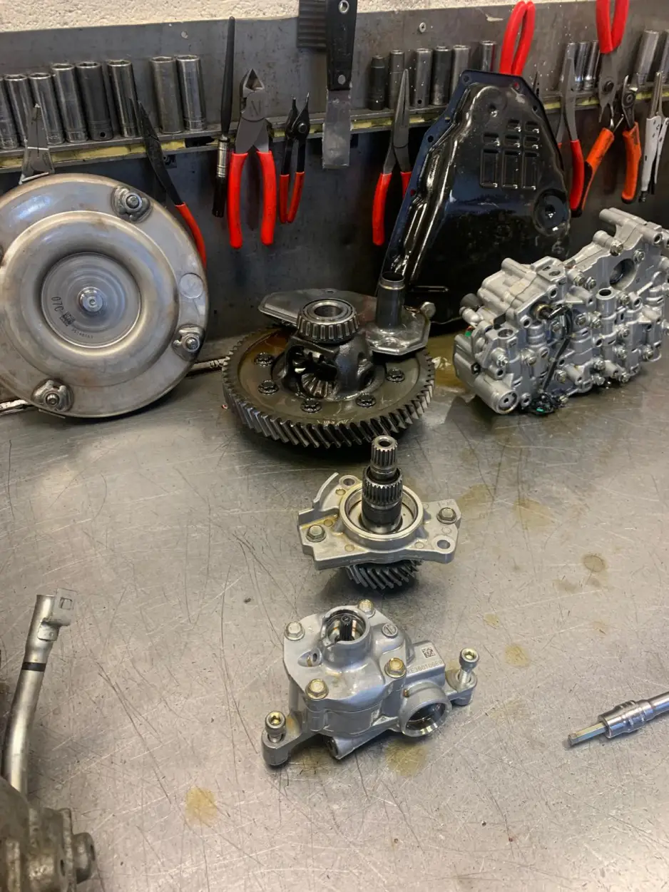 Disassembled Nissan gearbox components including torque converter, valve body and planetary gears